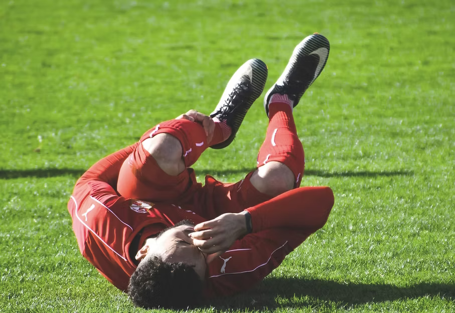 Promotional banner for Active Intelligence Pain Relief line, showing an injured soccer player lying on the grass.