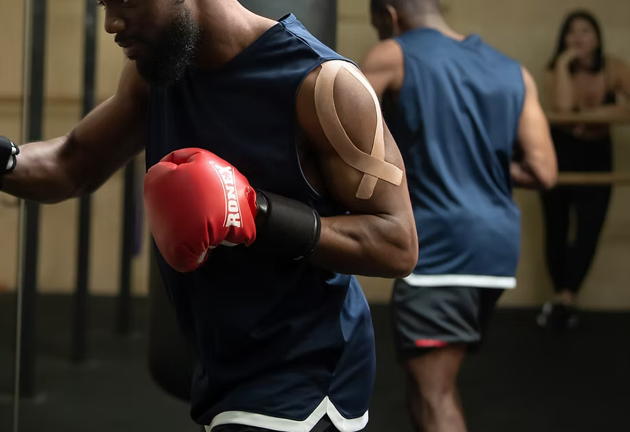 Promotional banner for Active Intelligence Performance Line, featuring a boxer with kinesiology tape on his shoulder.