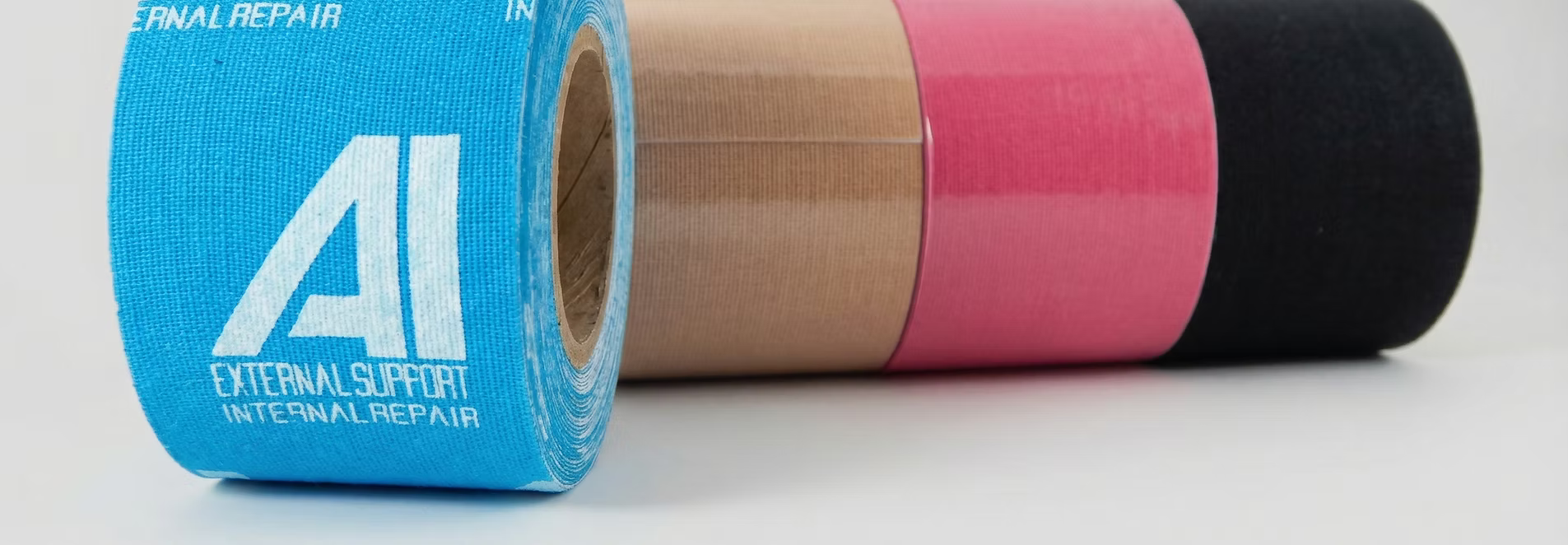 Four rolls of Active Intelligence kinesiology tape in blue, beige, pink, and black colors.